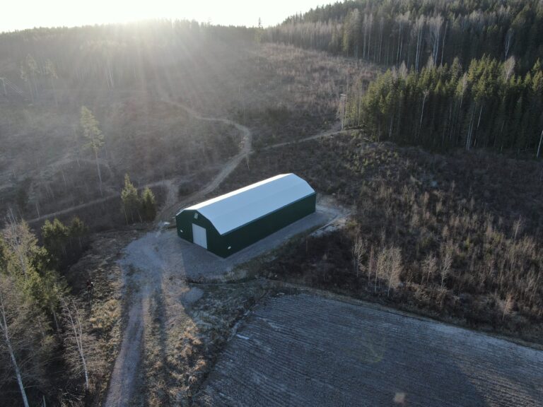 Grön maskinhall utanför Hedemora till förvaring av jordbruksmaskiner